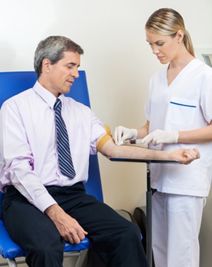 A health care professional taking a blood sample from a patient.
