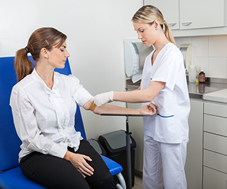A health care professional taking a blood sample from a patient.