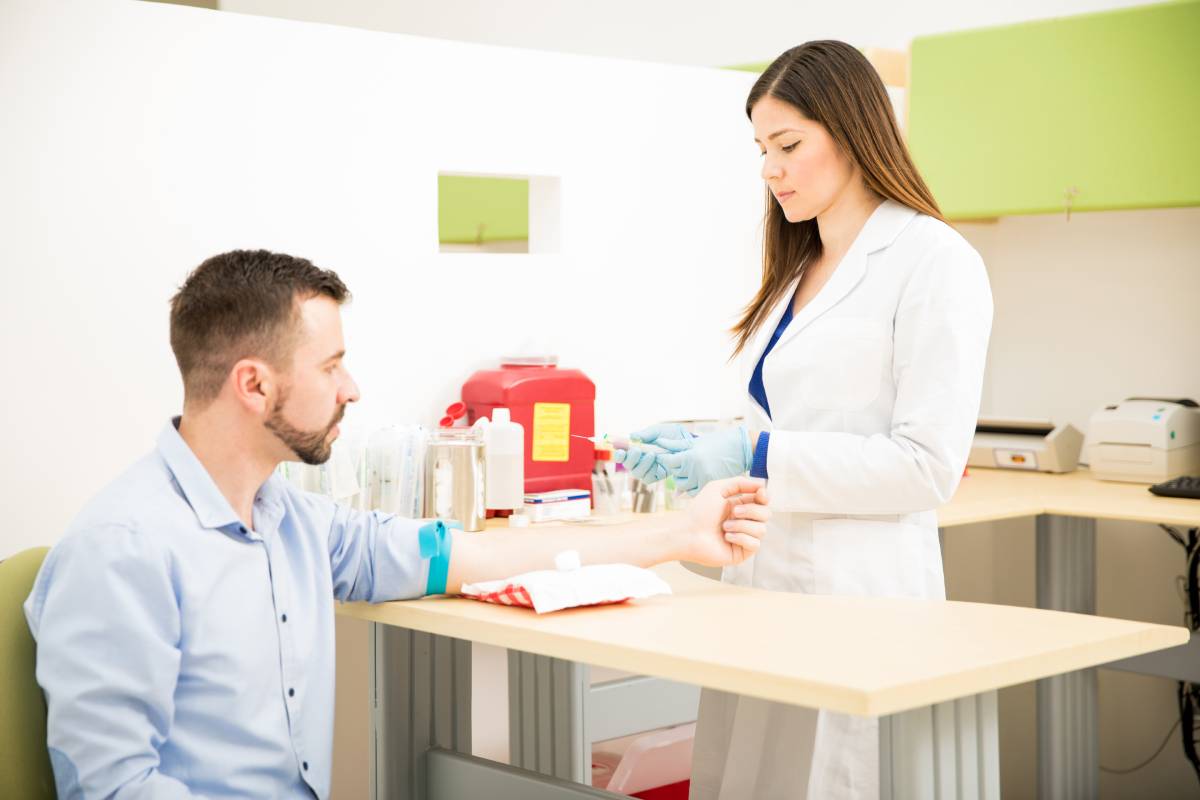 Profesional de atención de salud se prepara para tomar una muestra de sangre de un paciente.