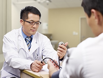 A health care professional takes a man’s blood pressure.