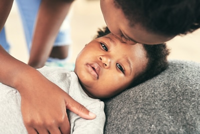 A mother comforting an unhappy baby.