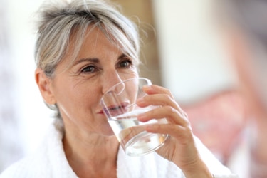 A woman drinking a glass of water.