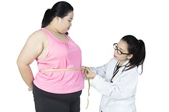 Doctor measuring a woman�s waist.