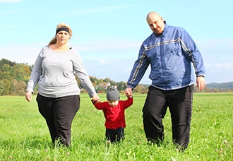 Overweight family walking together outdoors.