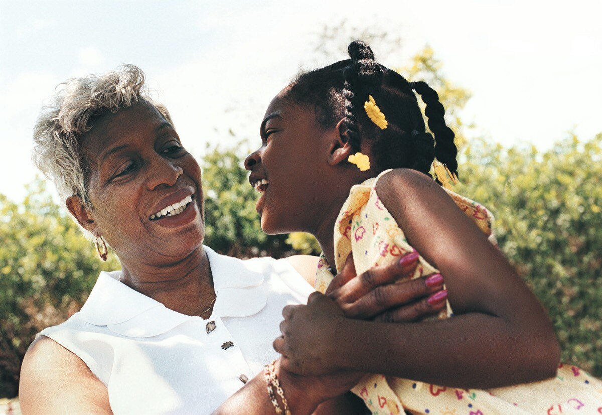 An older woman holds a young girl.