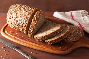 صورة لرغيف شرائح خبز الحبوب الكاملة على لوح تقطيع