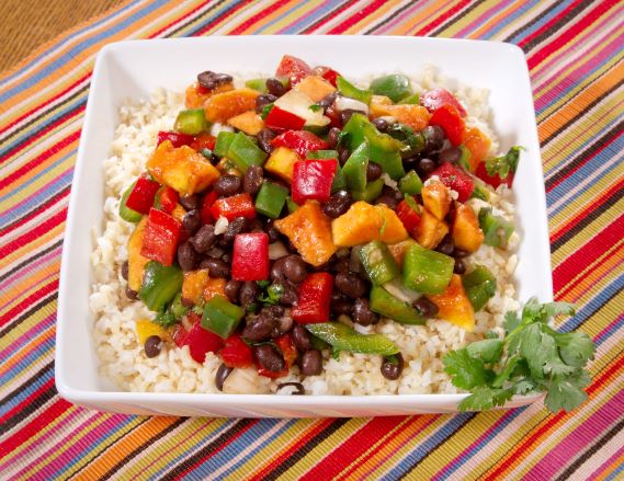  Dish of cooked black beans with bell peppers and brown rice.