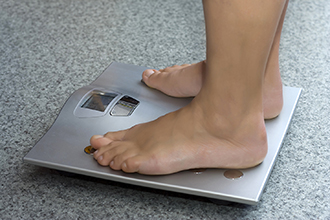 Patient standing on weight scale.