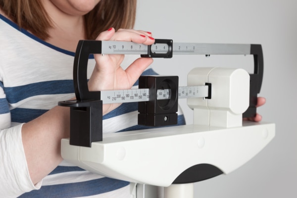 A woman weighing herself.