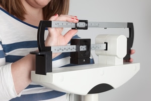 A woman weighing herself on a scale