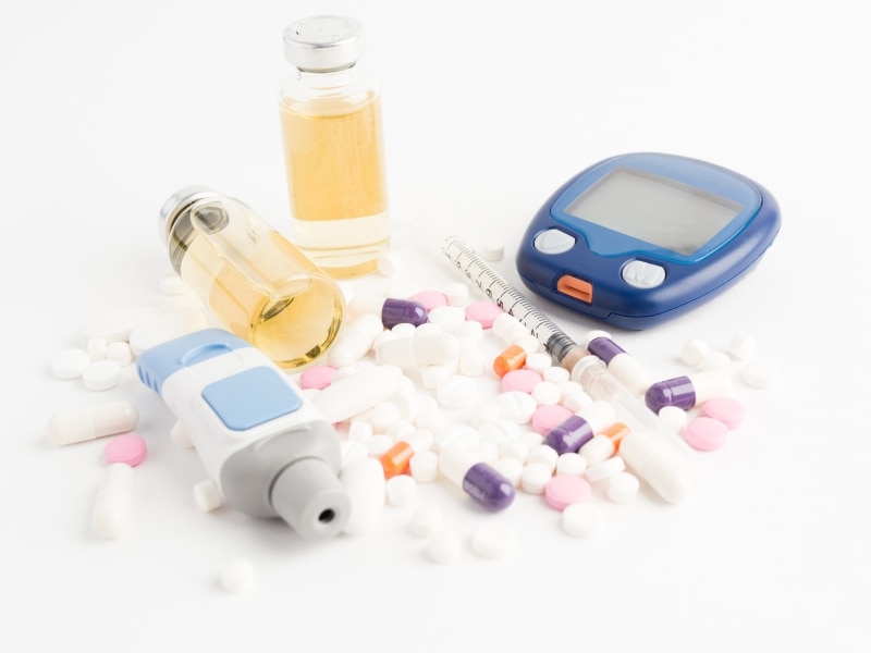 Diabetes blood testing supplies, pills, insulin, and a syringe