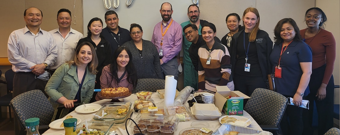 Fellows gathered around a table and smiling.