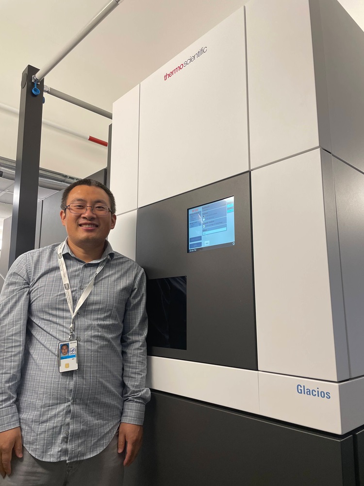 Photo of Dr. Cui next to the NIDDK Glacios cryo-EM microscope.