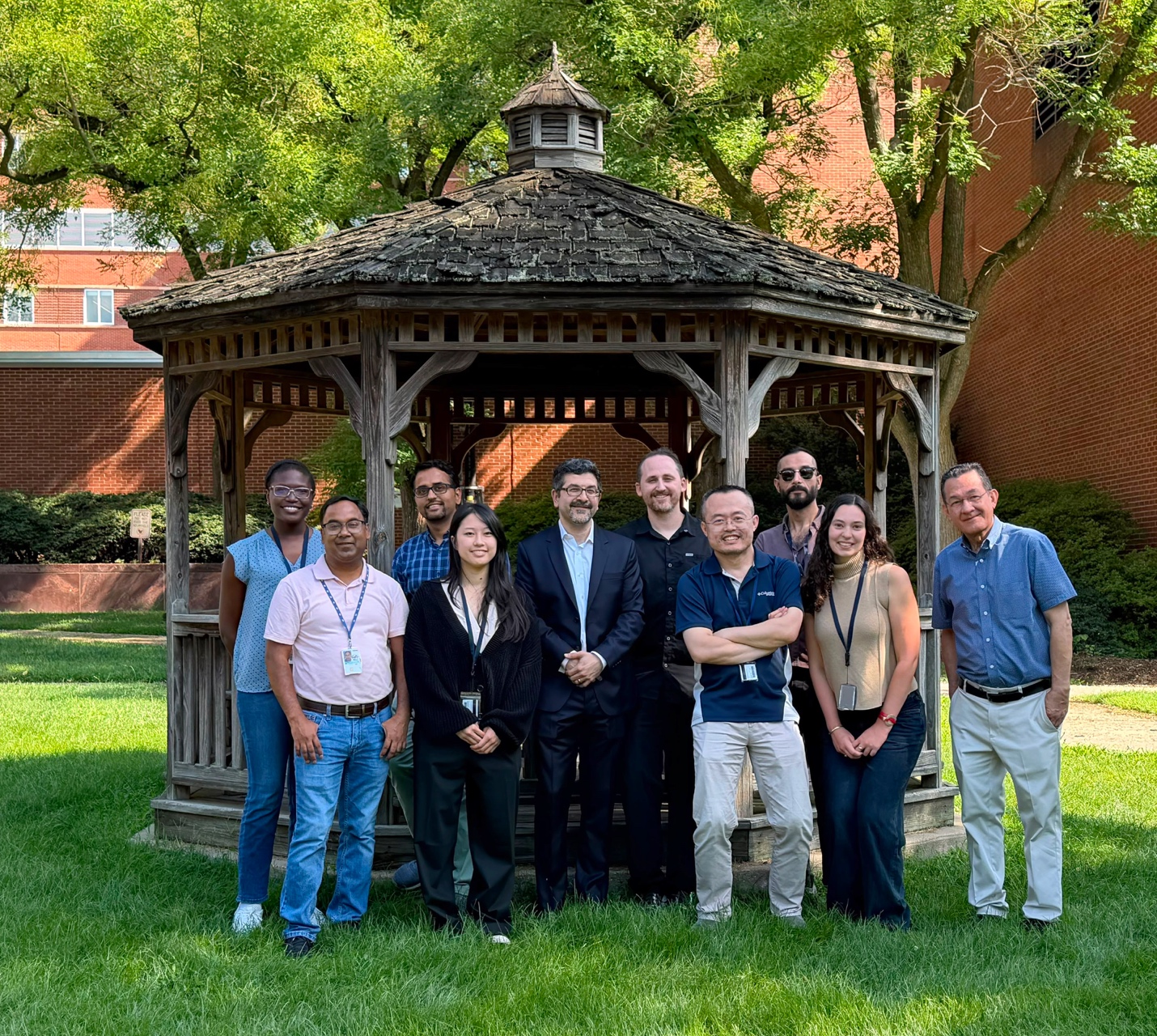 Members of the NIDDK immunoregulation section standing outdoors in front of a gazebo and smiling.