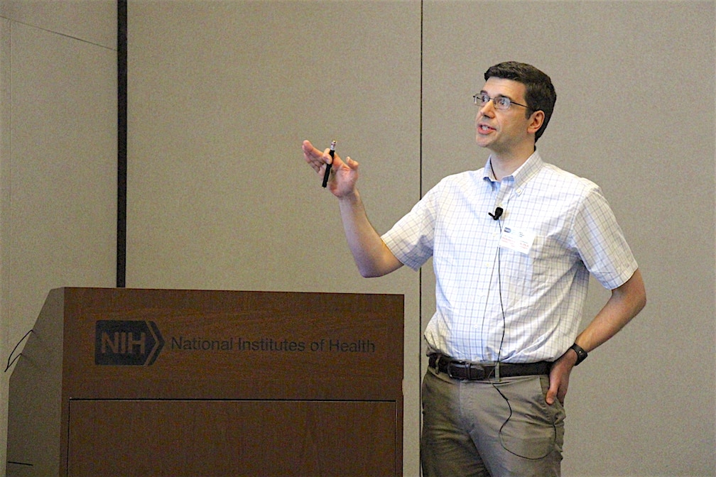 Dr. Guydosh standing at a lectern and pointing at a screen.