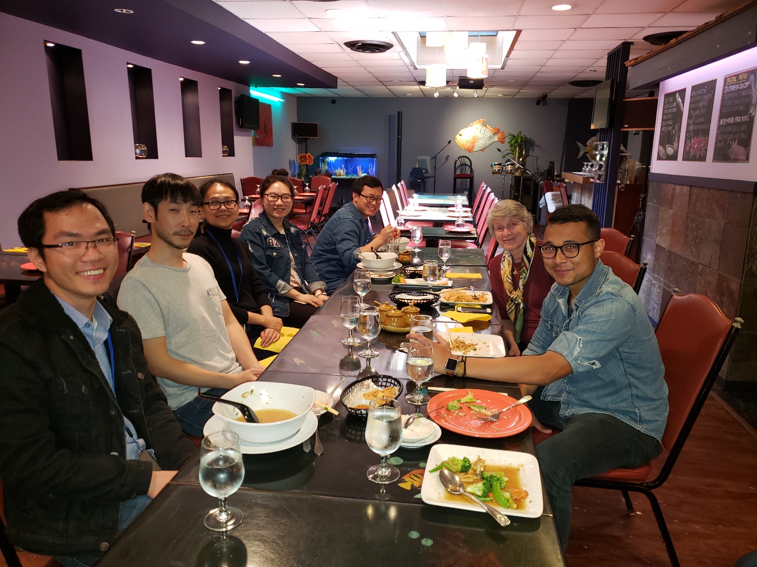 Members of the NIDDK Gene Regulation and Development Section sitting at a restaurant table and smiling.