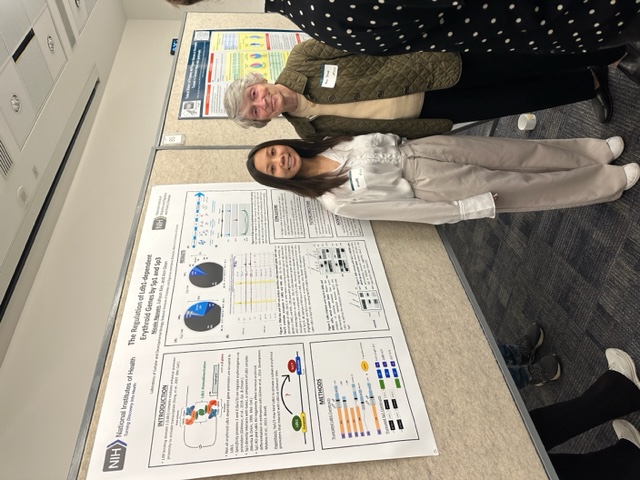 Nicole Nguyen and Ann Dean standing in front of a poster and smiling.