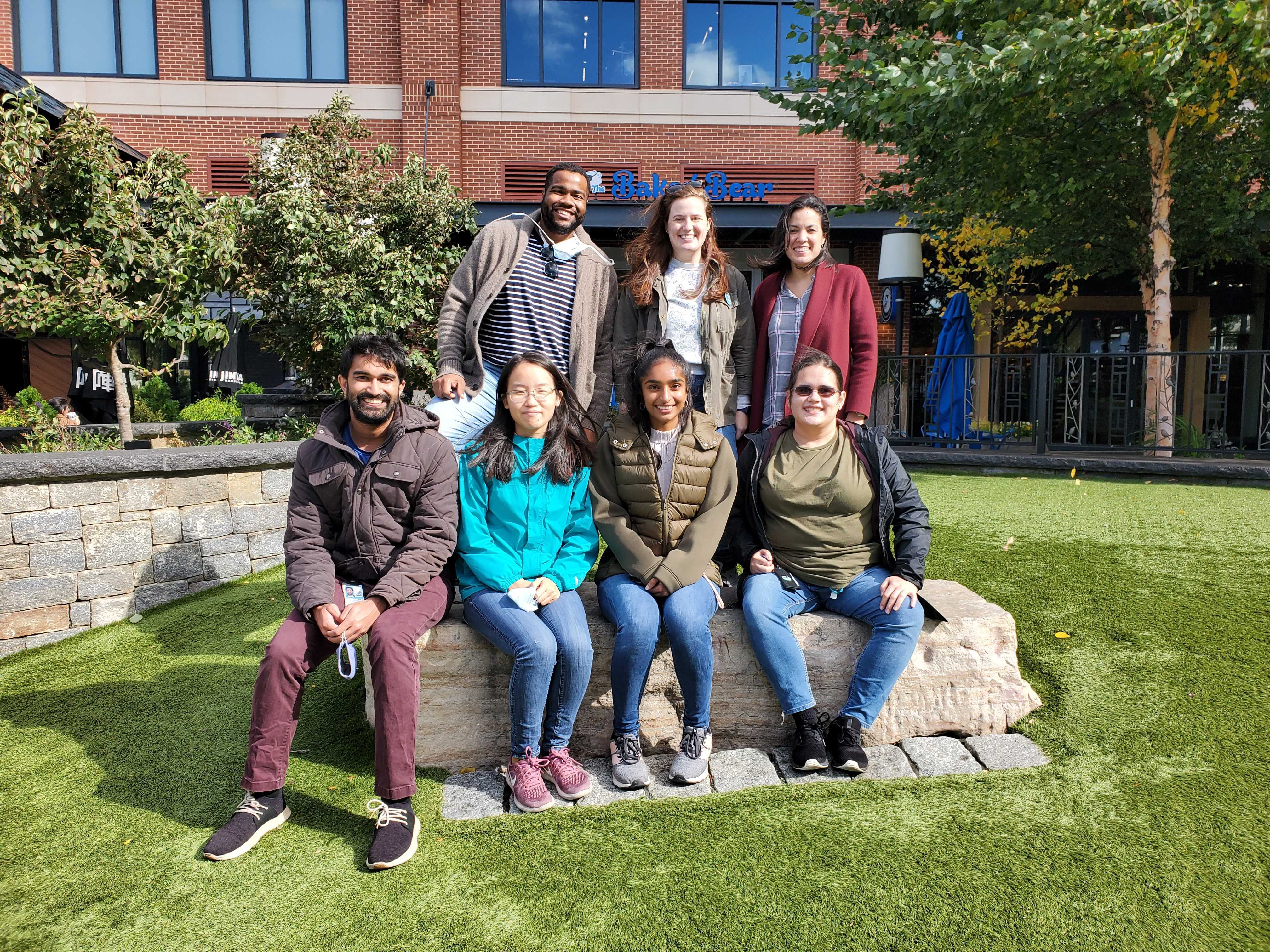 Photo of the lab members of the Section of Regulatory RNAs smiling and sitting in a park.