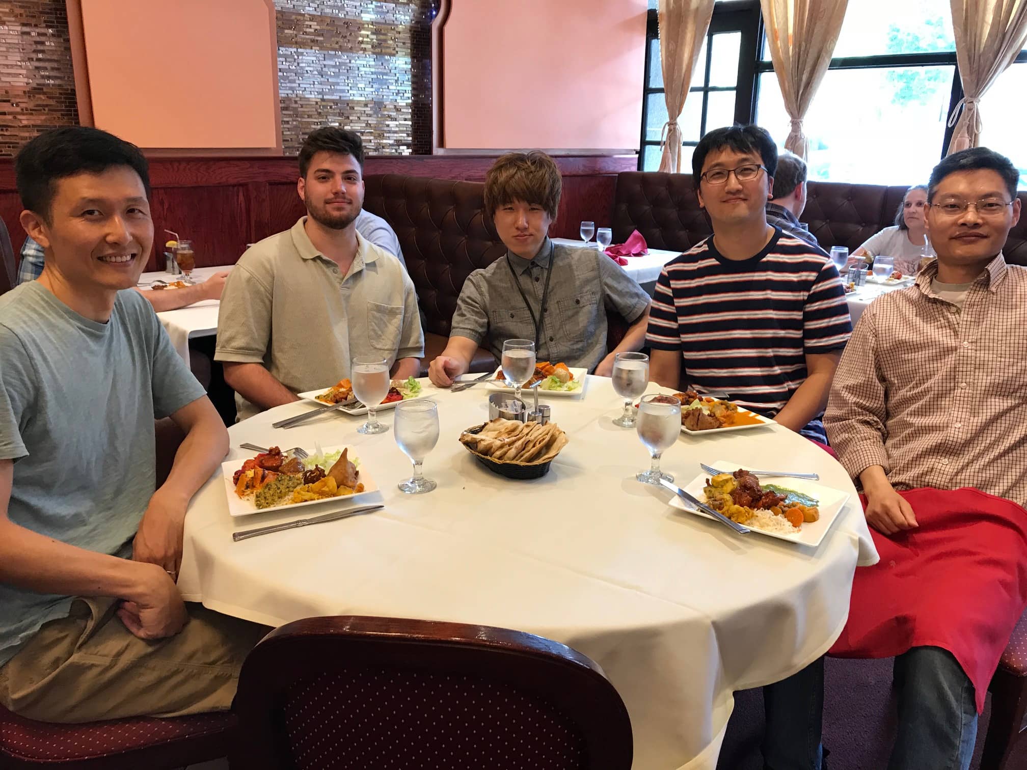 Members of the lab eat lunch around a table.