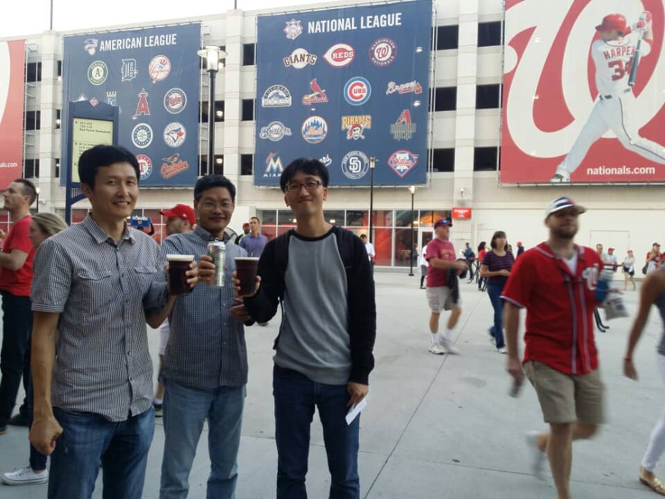 Members of the pose for a photo at a baseball game.