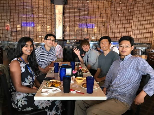 Members of the lab eat lunch around a table.