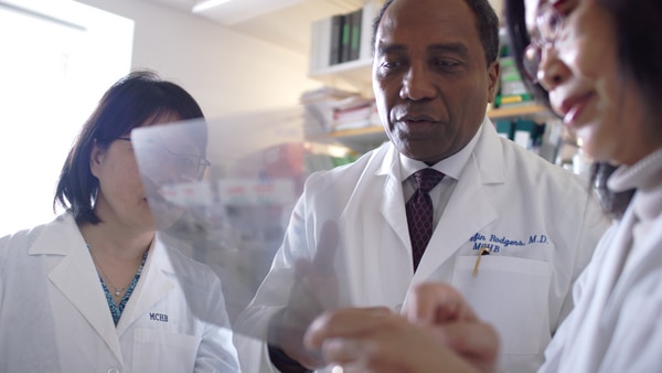 Dr. Rodgers with two scientists reviewing research in the MCHB lab