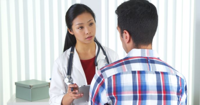 A health care professional talks with a patient.