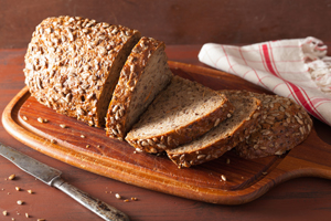 Photo of  sliced loaf of whole grain bread on a cutting board