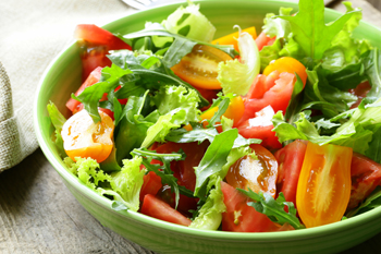 Photo of a fresh green salad with tomatoes in a bowl